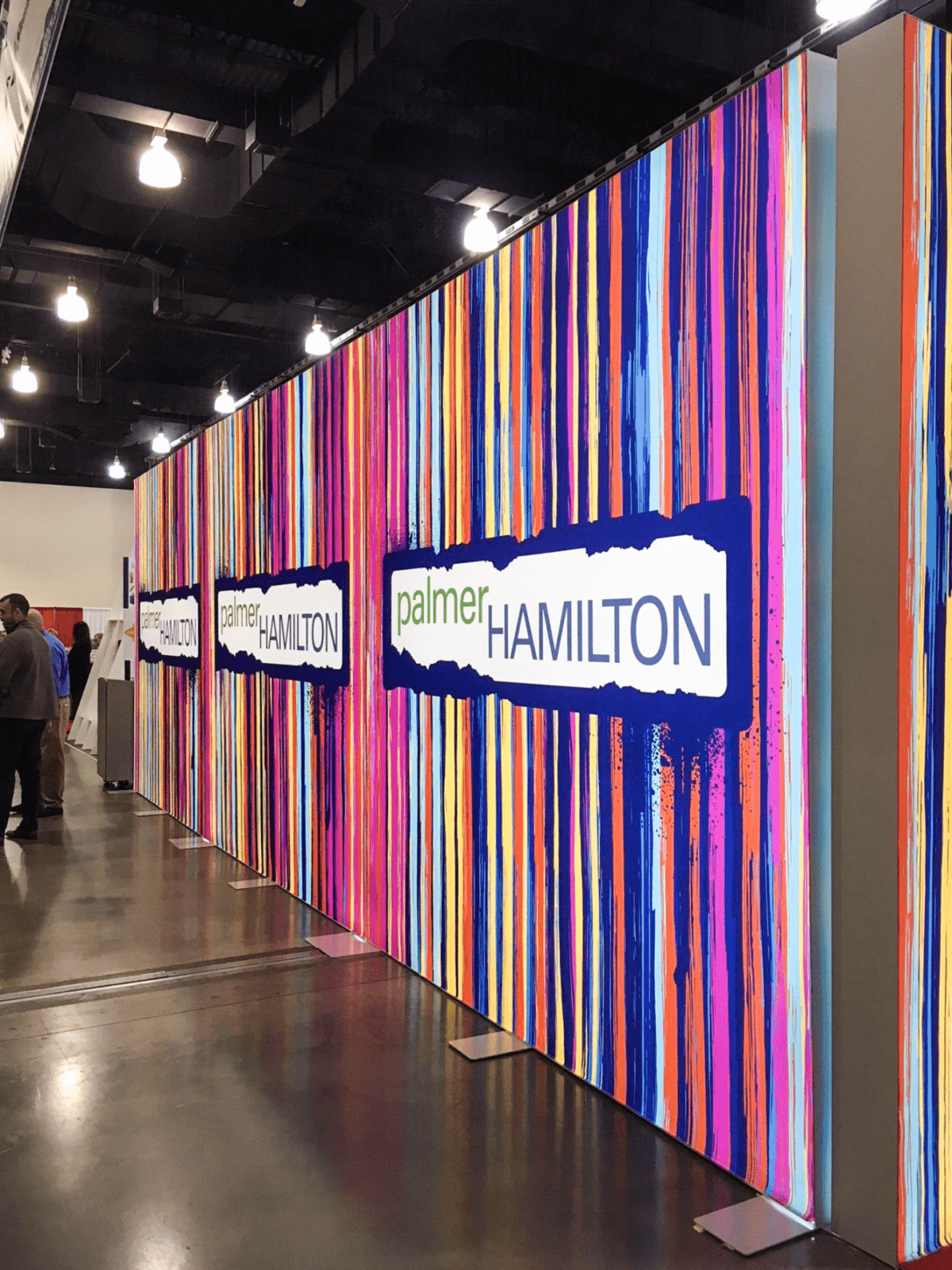 Palmer Hamilton Trade Show Booth that uses freestanding and arched lightboxes to create an environment